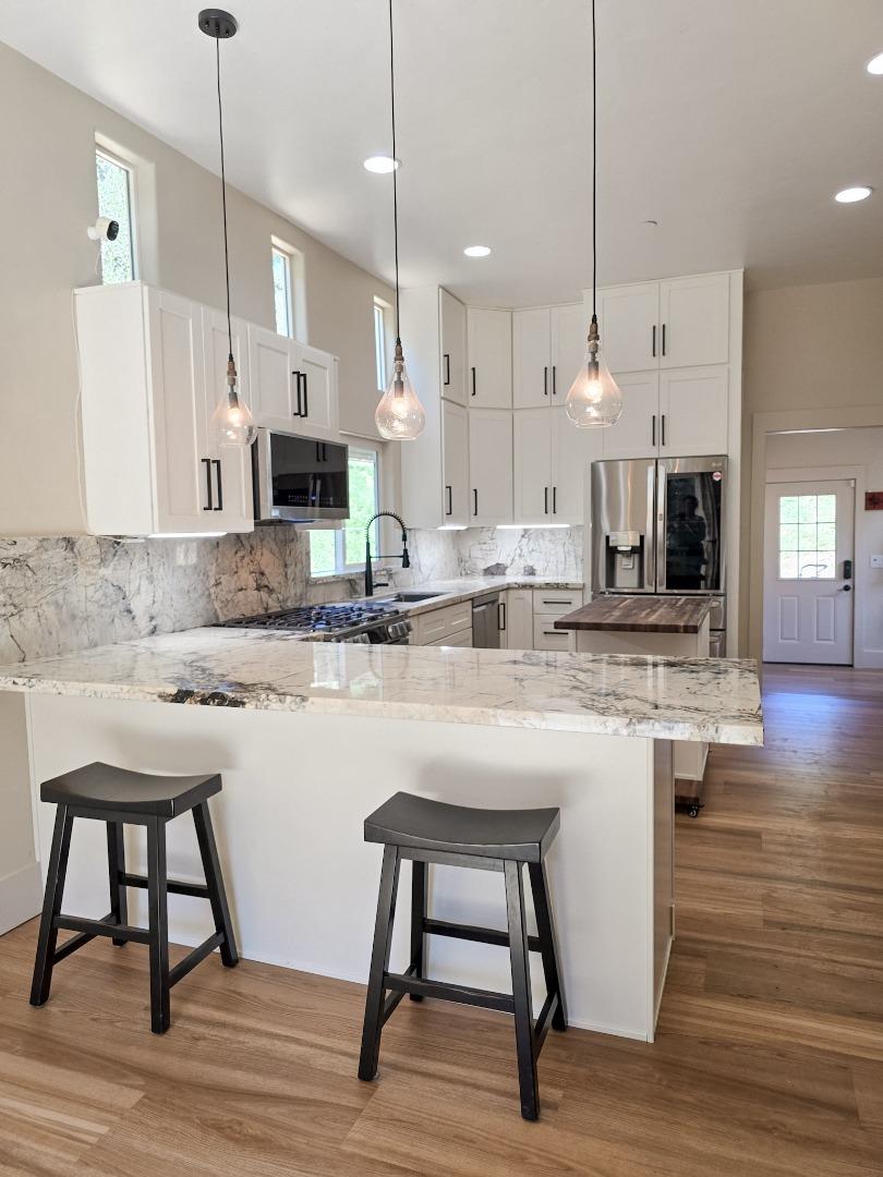 17329 McGuffie Road Salinas, CA 93907 - Photo 4 of 27 a kitchen with kitchen island a dining table chairs and a wooden floor