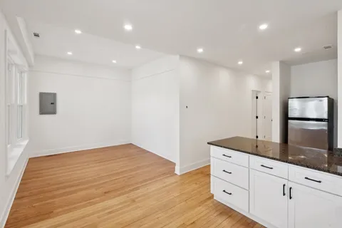 a view of a kitchen with wooden floor and window