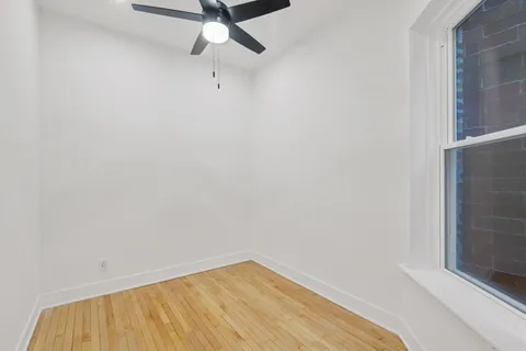 a view of a room with wooden floor and fan