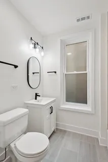 a bathroom with a toilet a sink and mirror