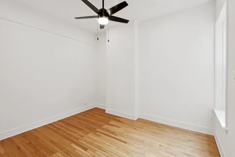 an empty room with a fan and a window