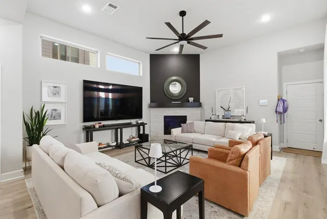 a living room with furniture a flat screen tv and a fireplace