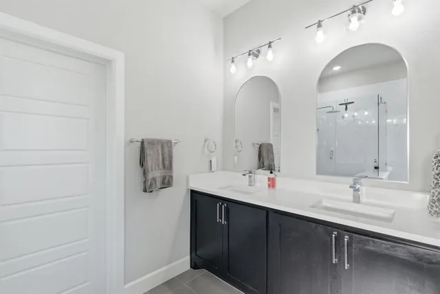 a bathroom with a double vanity sink and a mirror
