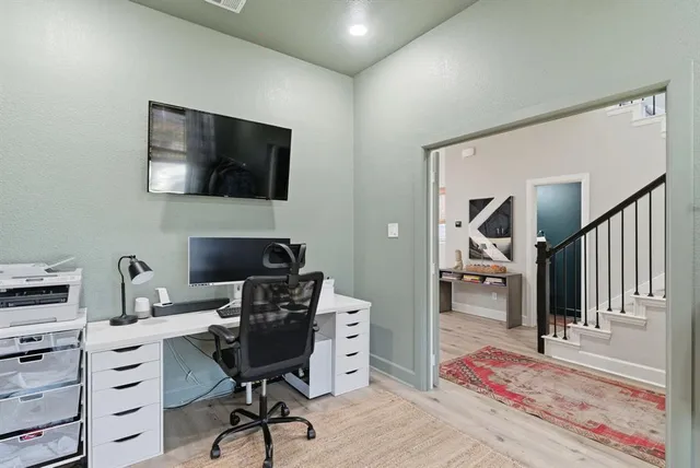 a view of a workspace with furniture and a window