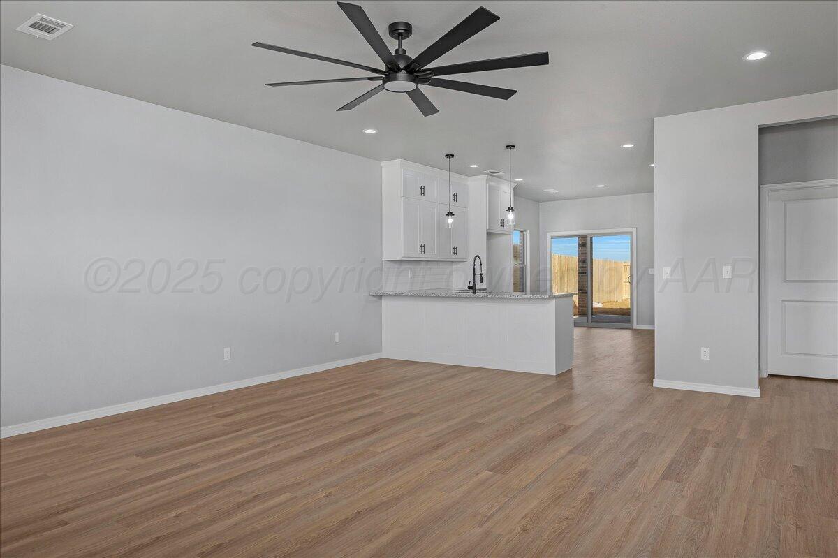 4300 Beacon Road Amarillo, TX 79118 - Photo 5 of 20 a view of a big room with wooden floor and a kitchen