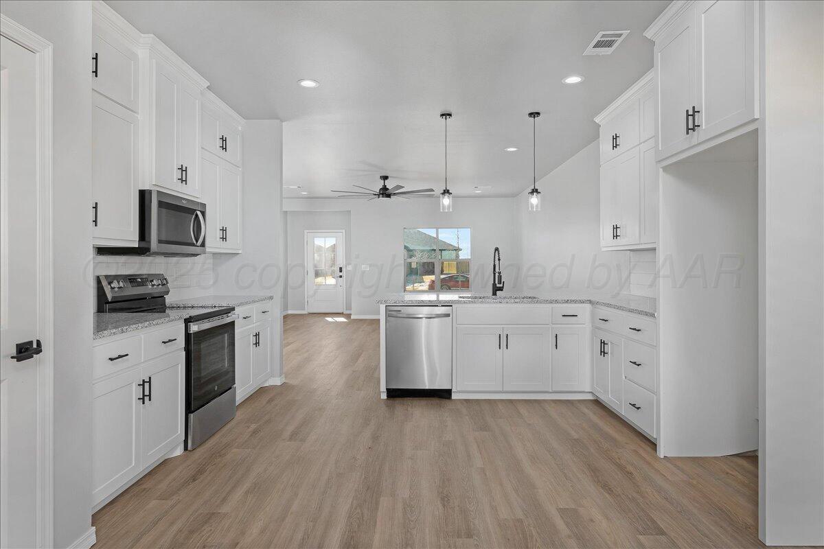 4300 Beacon Road Amarillo, TX 79118 - Photo 8 of 20 a kitchen with white cabinets and stainless steel appliances