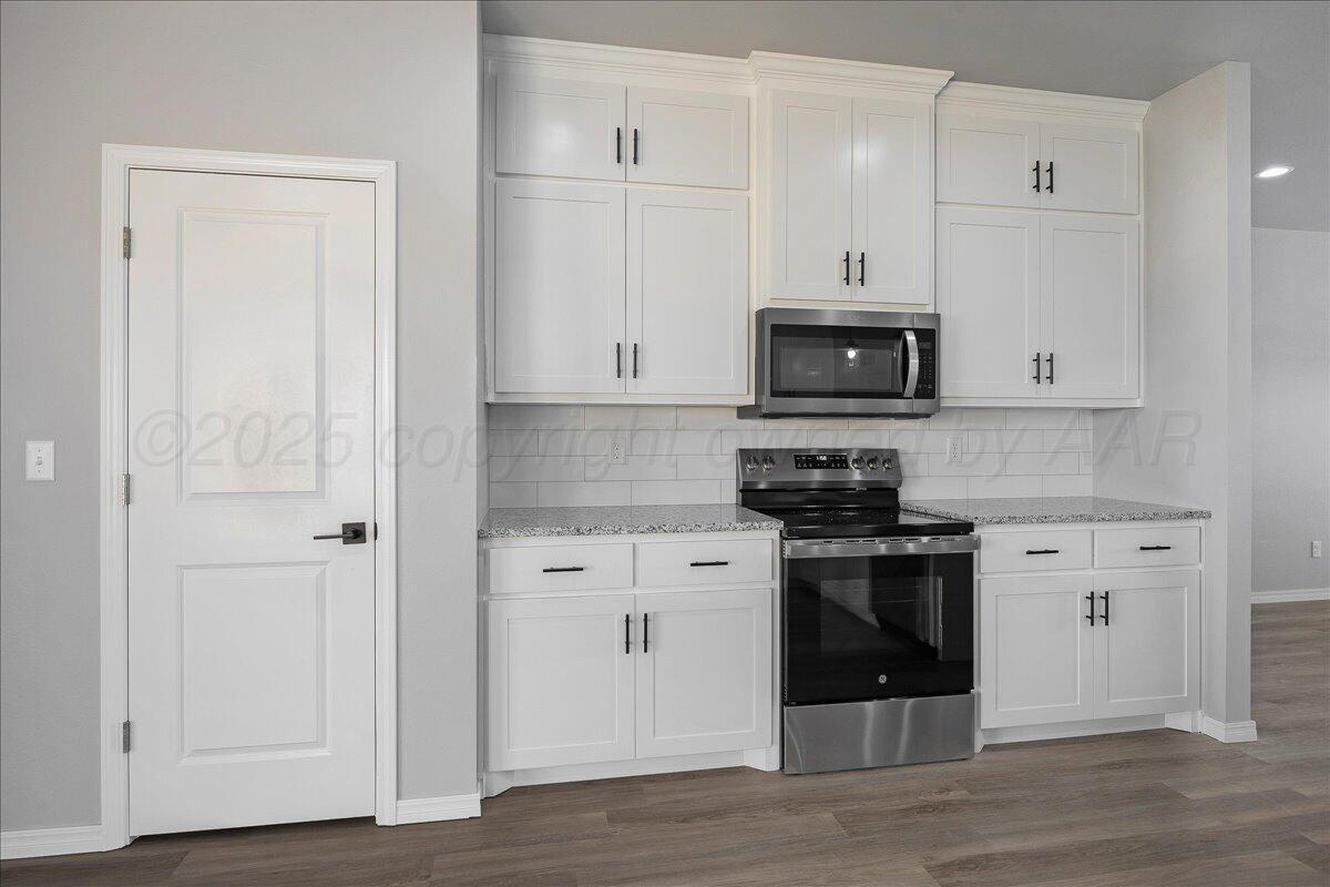4300 Beacon Road Amarillo, TX 79118 - Photo 10 of 20 a kitchen with stainless steel appliances granite countertop a stove and a microwave