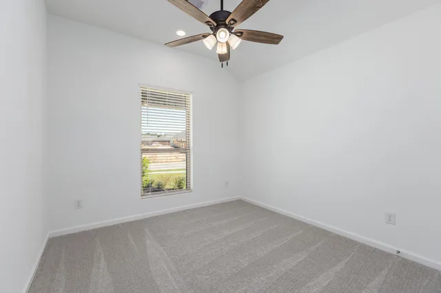 an empty room with a window and a fan