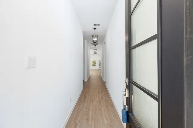 a view of a hallway with wooden floor and staircase