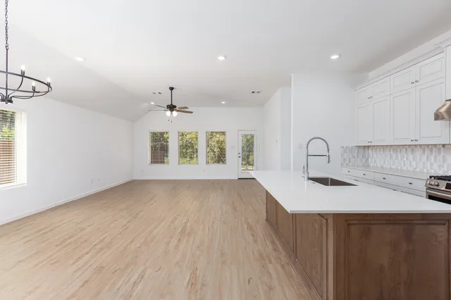 a kitchen with a sink wooden floor and window