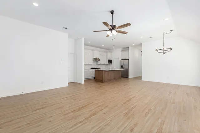 a view of a big room with wooden floor and windows