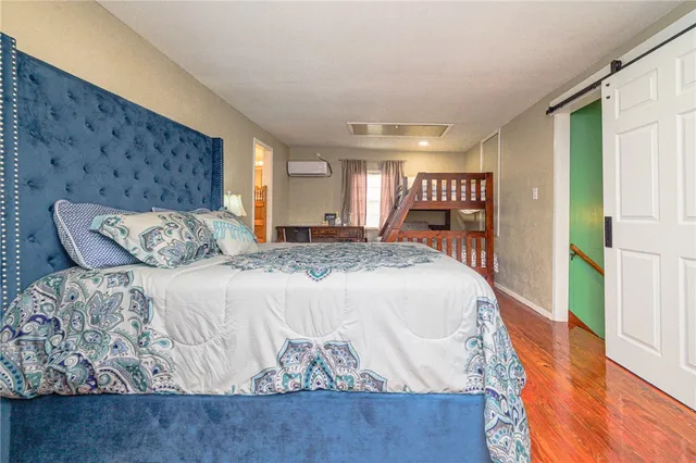 a bedroom with furniture and a wooden floor