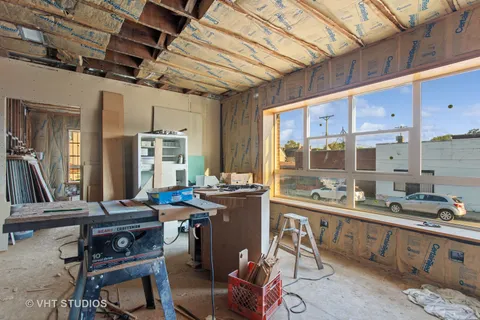 a room with lots of wooden furniture and windows