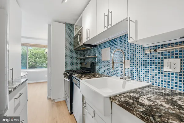 a kitchen with a sink a stove and a microwave