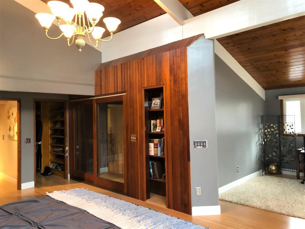149 Wheeler Road Mashpee, MA 02649 - Photo 22 of 41 a view of a hallway with wooden floor and a chandelier