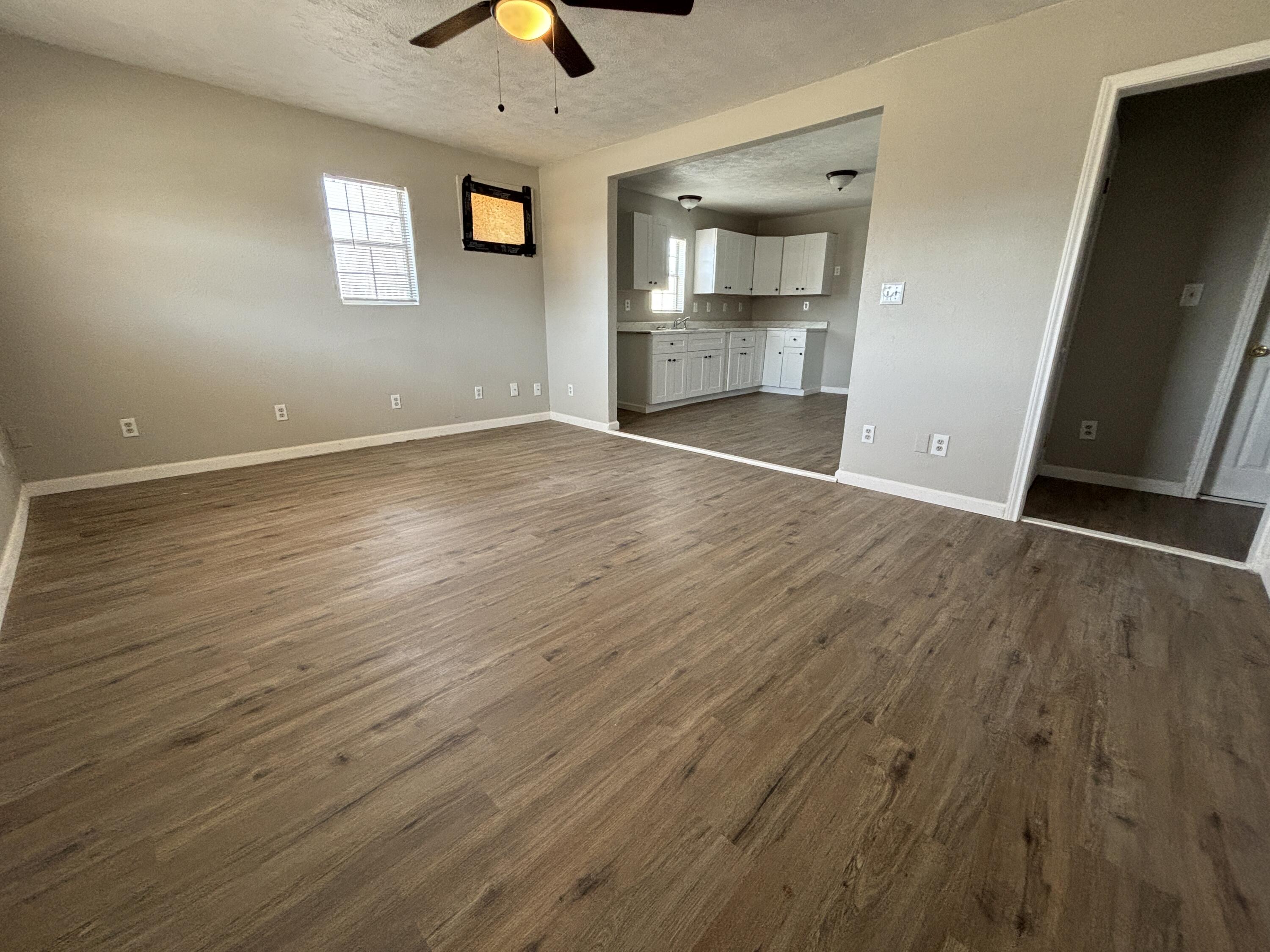 4822 37th Street Lubbock, TX 79414 - Photo 2 of 12 an empty room with wooden floor and windows