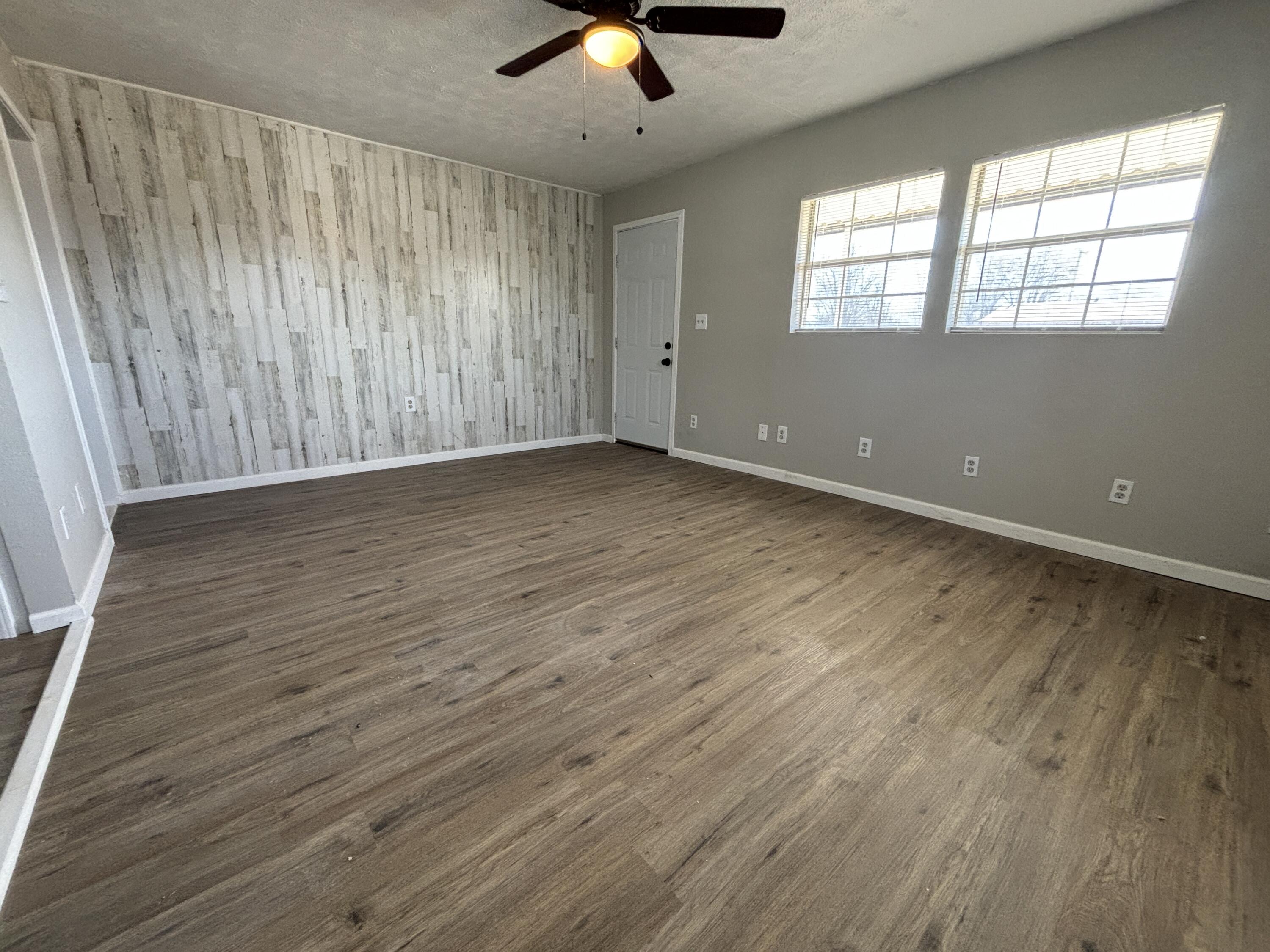 4822 37th Street Lubbock, TX 79414 - Photo 3 of 12 wooden floor in an empty room with a window