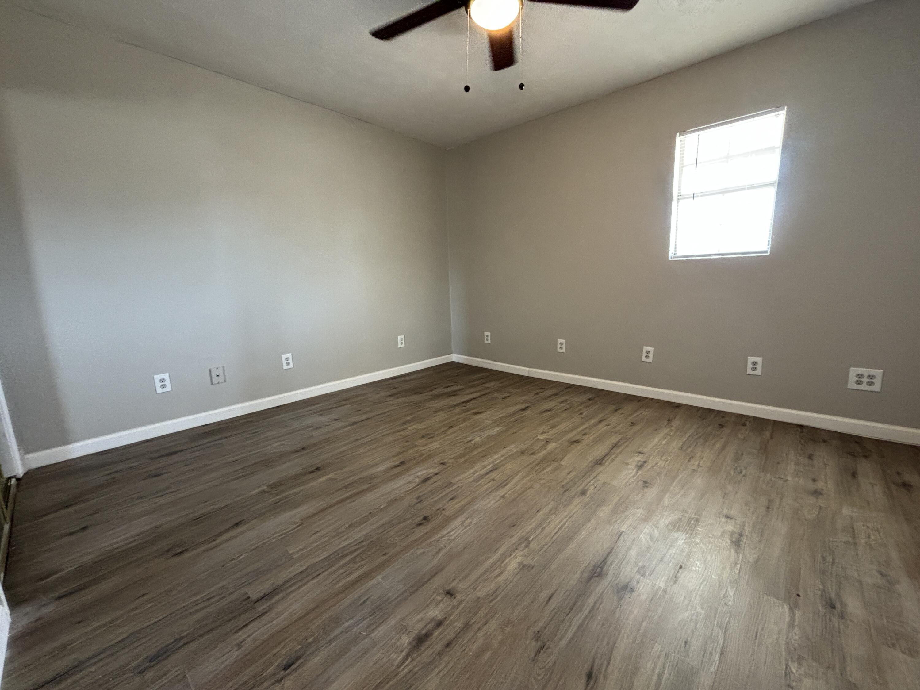 4822 37th Street Lubbock, TX 79414 - Photo 6 of 12 an empty room with wooden floor and windows