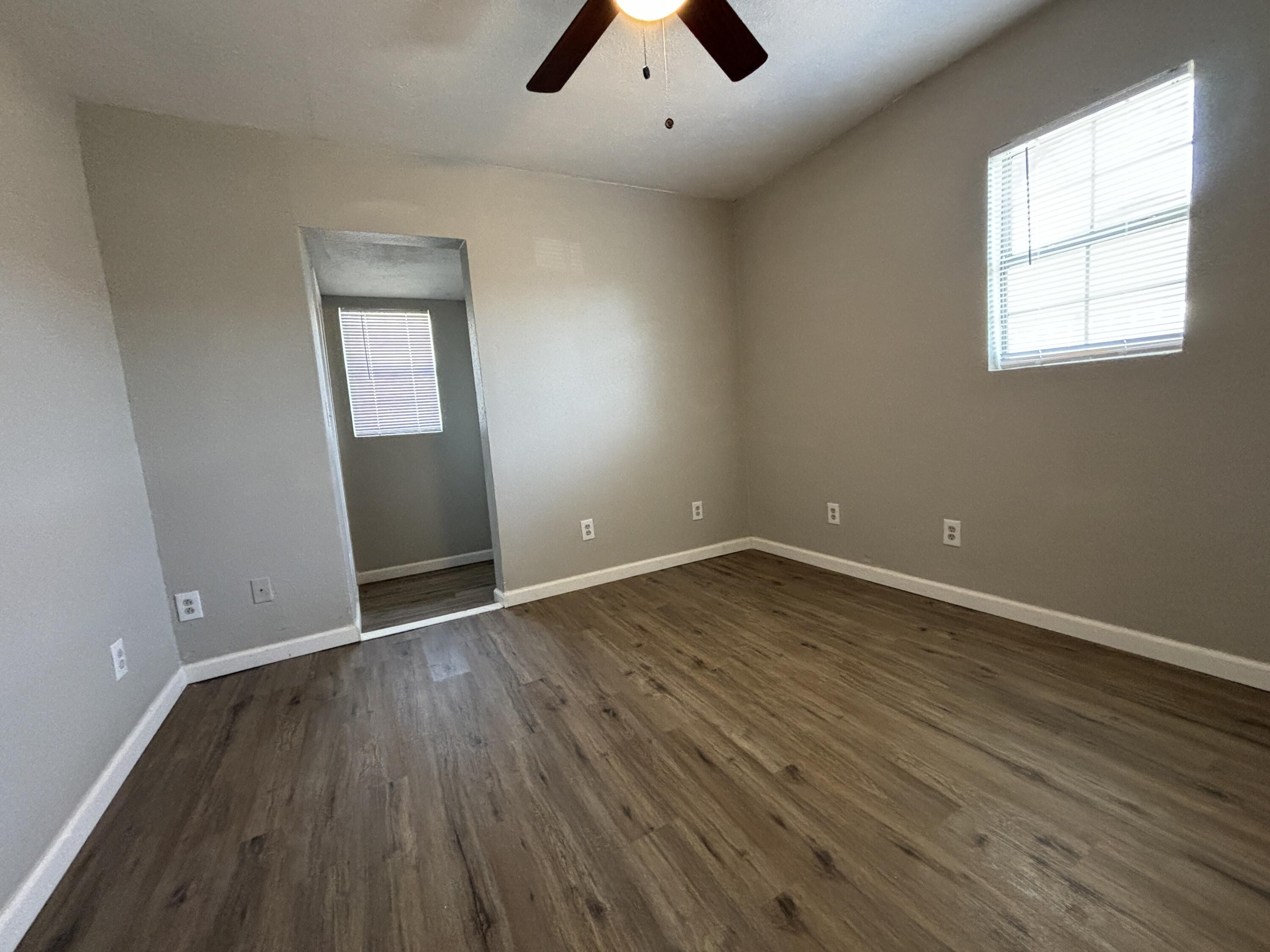 4822 37th Street Lubbock, TX 79414 - Photo 7 of 12 an empty room with wooden floor and windows
