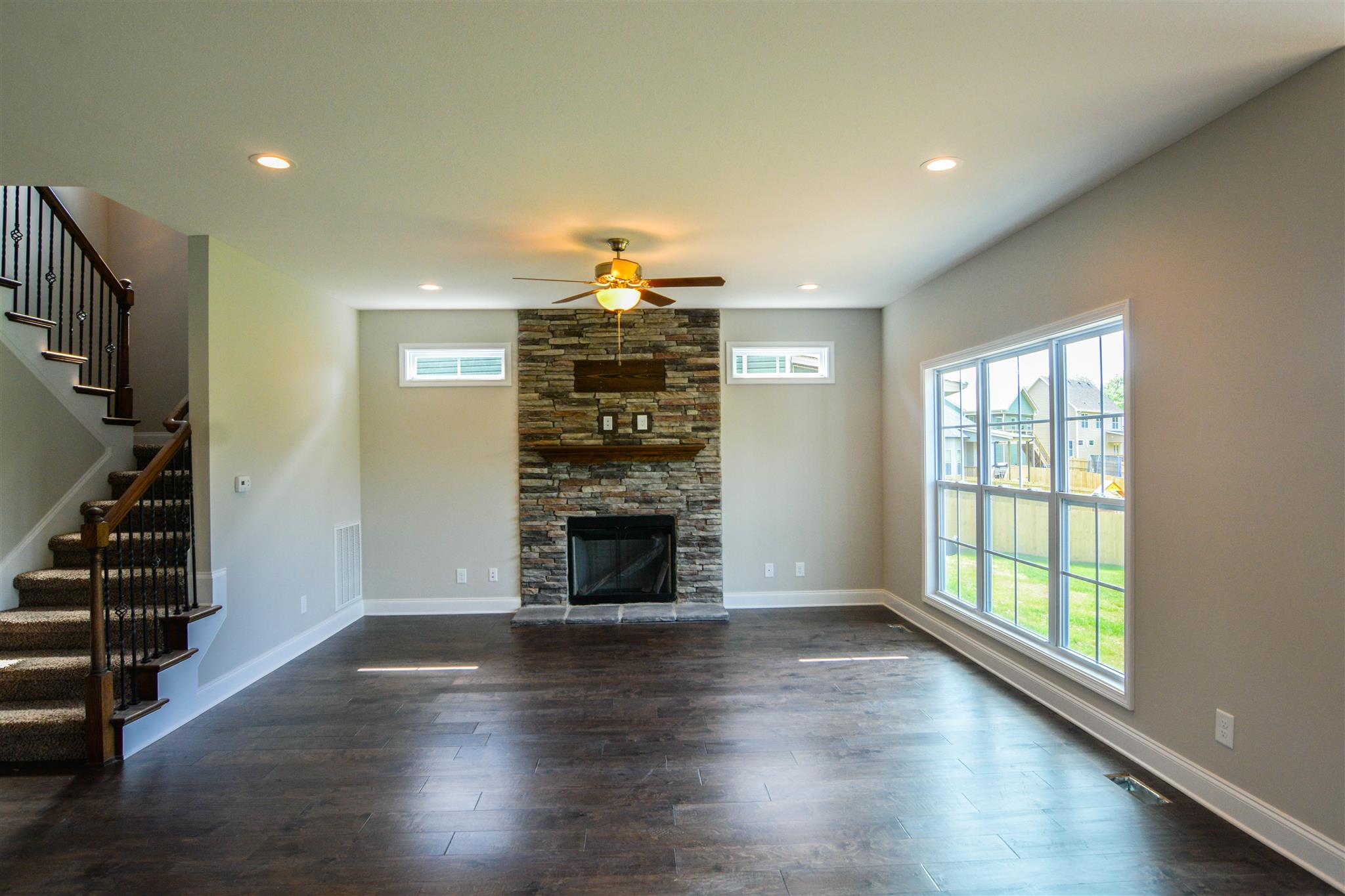 780 Grays Chapel Road Southside, TN 37171 - Photo 11 of 30 an empty room with wooden floor fireplace and windows