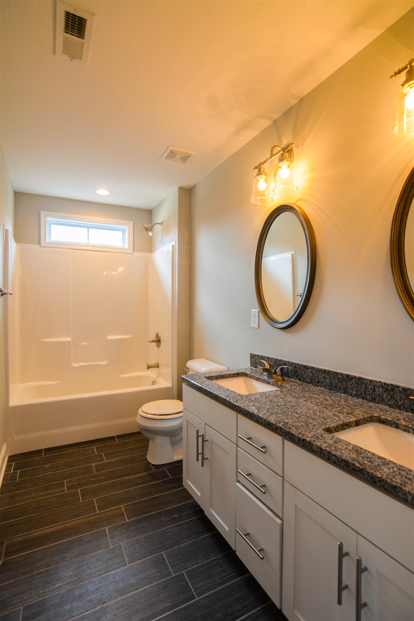 780 Grays Chapel Road Southside, TN 37171 - Photo 24 of 30 a bathroom with a granite countertop toilet a sink and a mirror