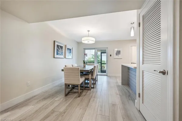 a dining room with wooden floor a chandelier a wooden table and chairs