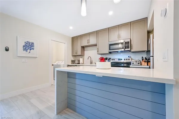 a kitchen with kitchen island granite countertop wooden cabinets and white appliances