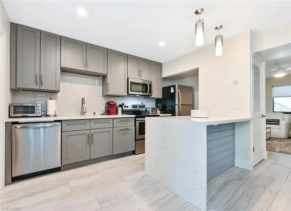 a kitchen with kitchen island granite countertop a sink cabinets and wooden floor