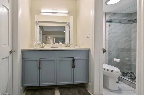 a bathroom with a granite countertop shower and a toilet
