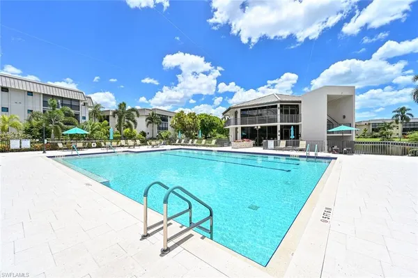 a swimming pool with lots of tress in front of it