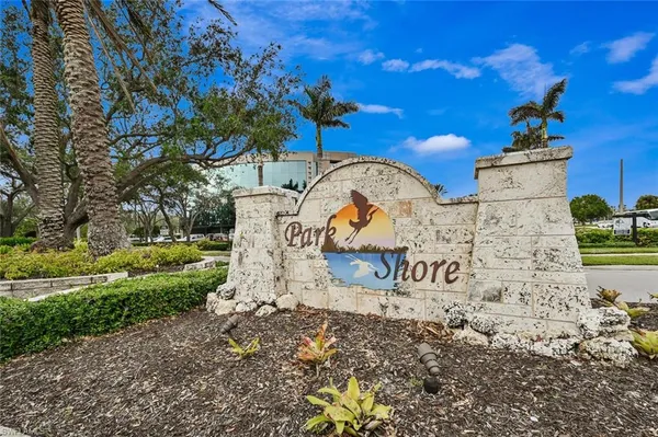 a sign board with buildings in the background