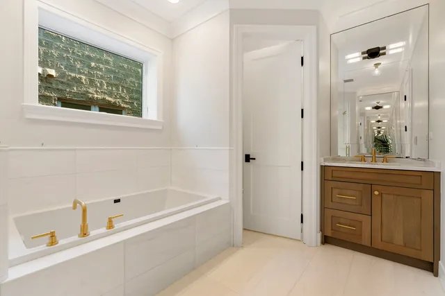 a bathroom with a tub sink and mirror