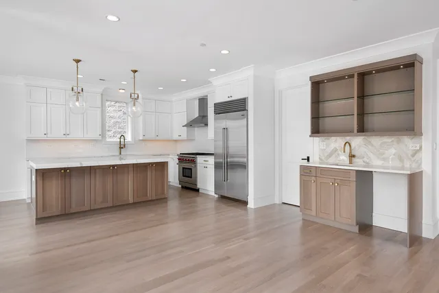 a large kitchen with a center island stainless steel appliances and a counter space