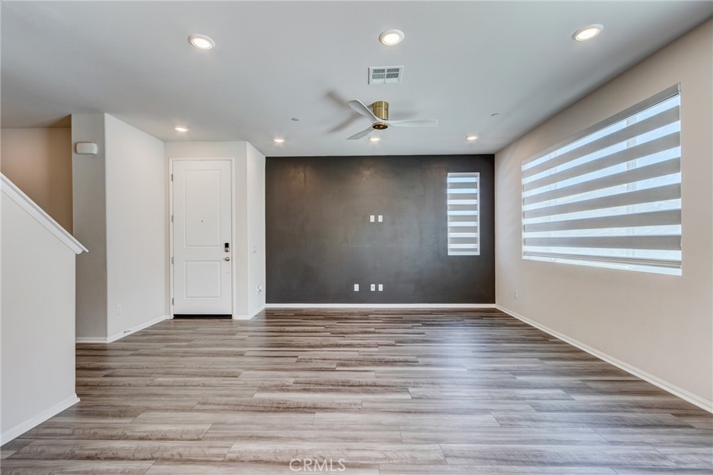 36469 Shine Drive Winchester, CA 92596 - Photo 12 of 73 an empty room with wooden floor and windows