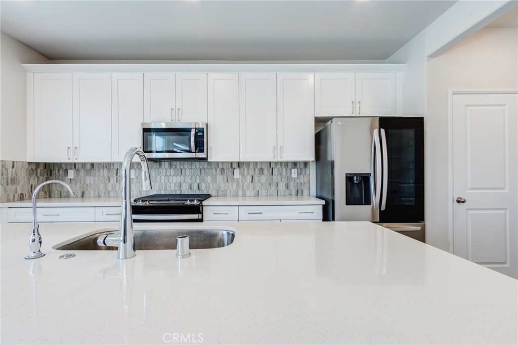 36469 Shine Drive Winchester, CA 92596 - Photo 3 of 73 a kitchen with granite countertop a refrigerator and a stove top oven