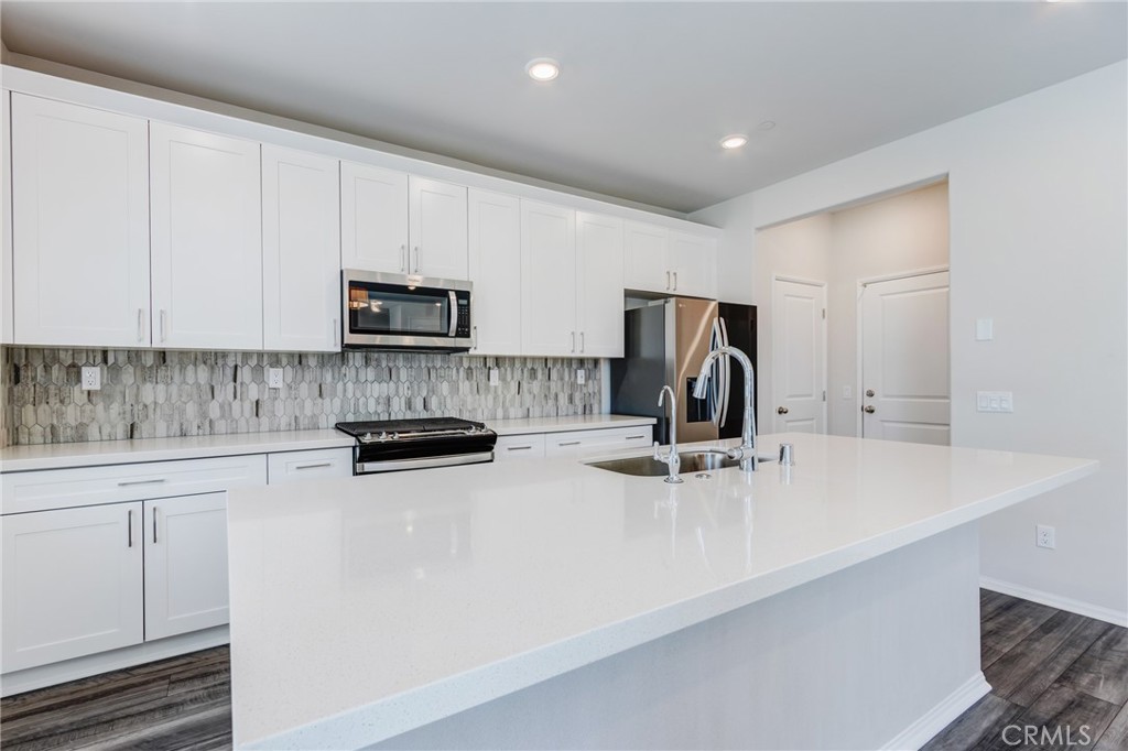 36469 Shine Drive Winchester, CA 92596 - Photo 5 of 73 a kitchen with kitchen island a stove a sink and a microwave
