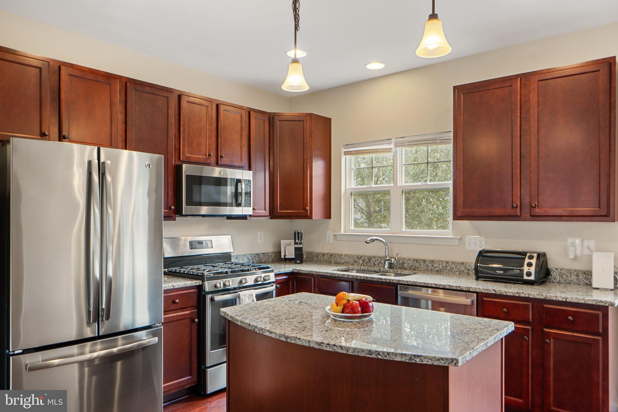 2210 Mallard Landing Drive Fredericksburg, VA 22408 - Photo 12 of 30 a kitchen with granite countertop wooden cabinets a sink stainless steel appliances and a window