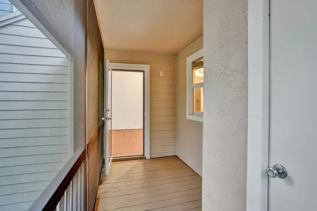 a view of a hallway with wooden floor and staircase