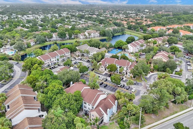 an aerial view of residential houses with outdoor space and trees
