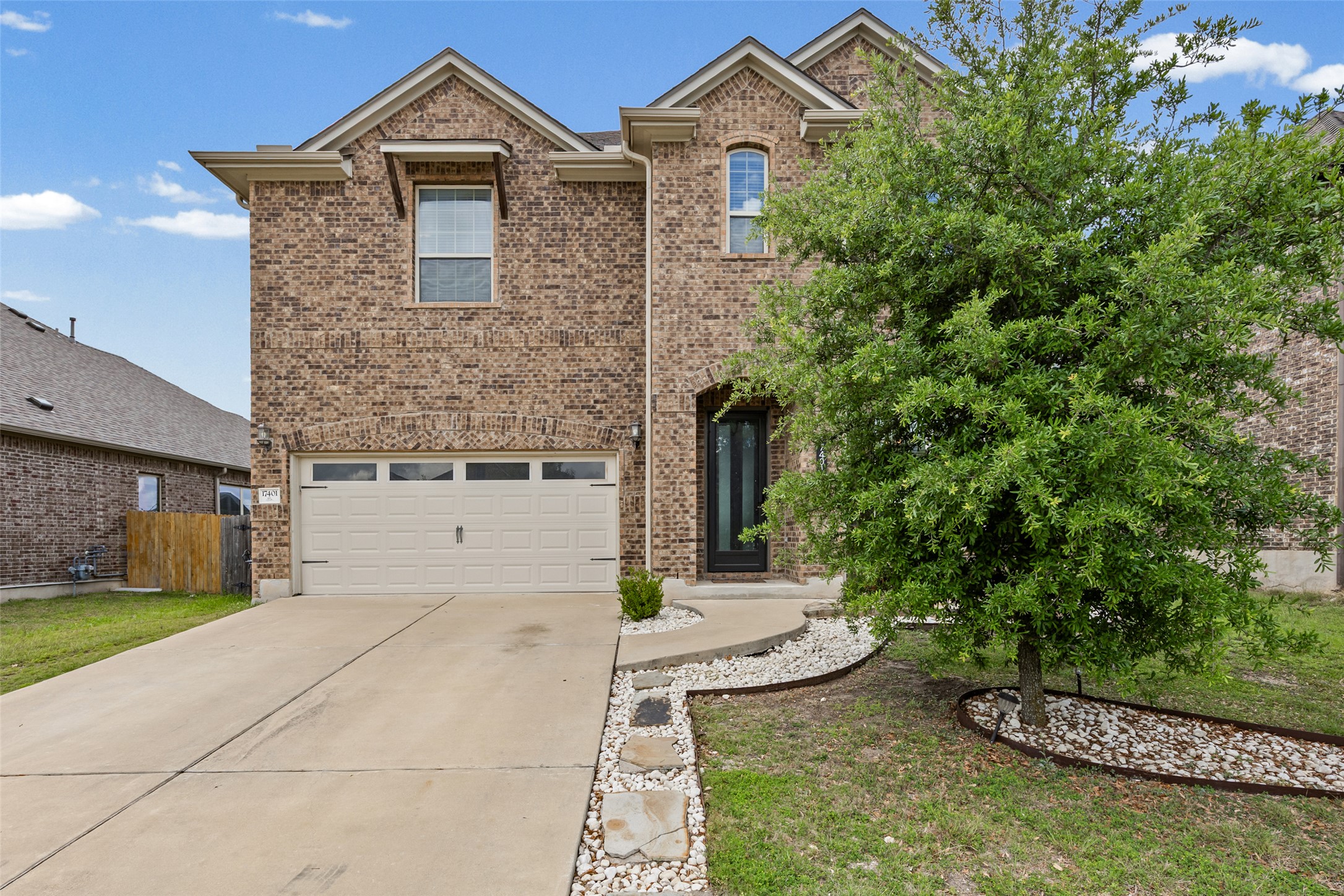 Traditional-style home with brick siding, a garage, and driveway