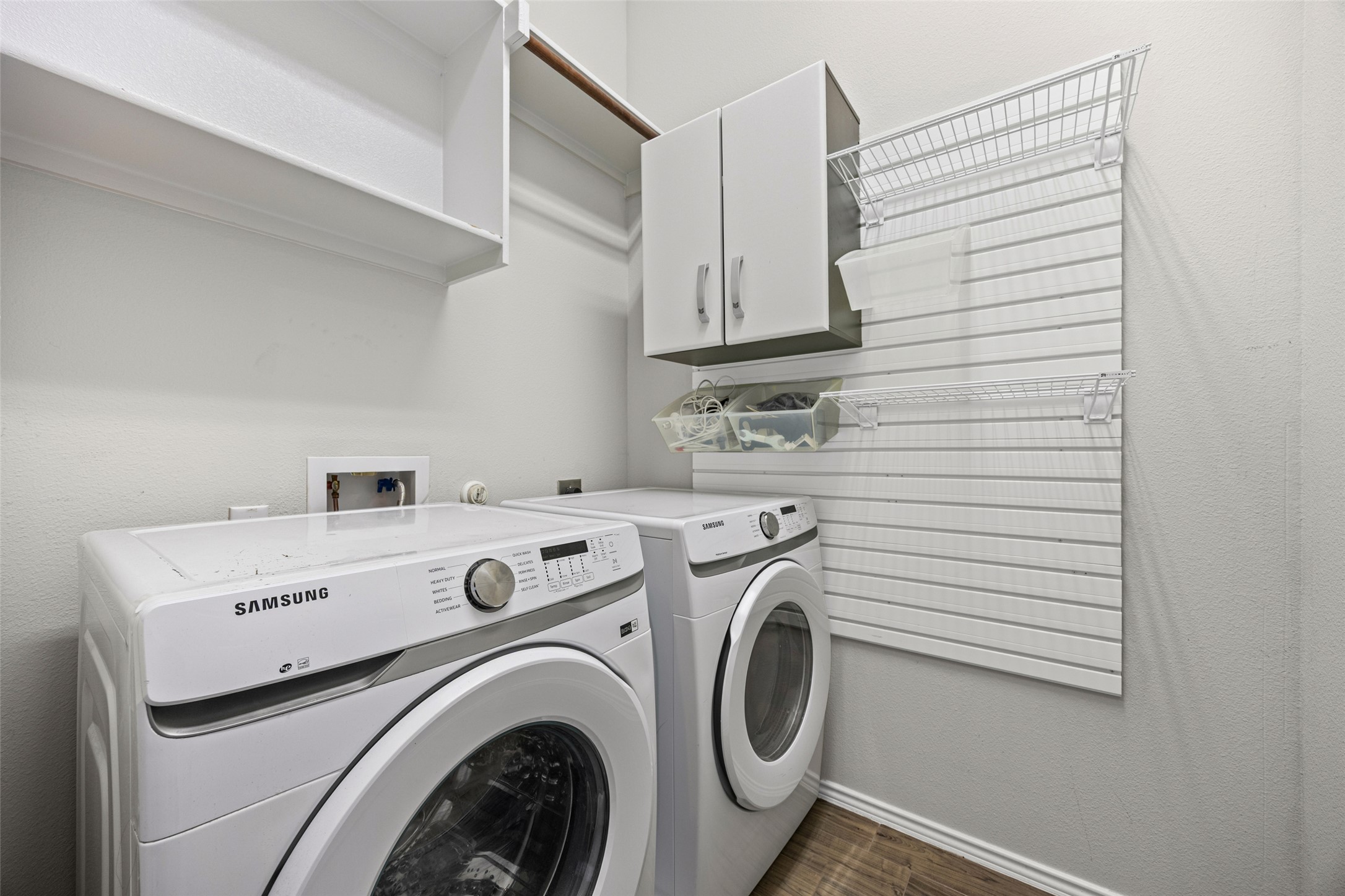 17401 Silent Harbor Loop Pflugerville, TX 78660 - Photo 11 of 37 Laundry room featuring washer and clothes dryer, cabinet space, and a textured wall