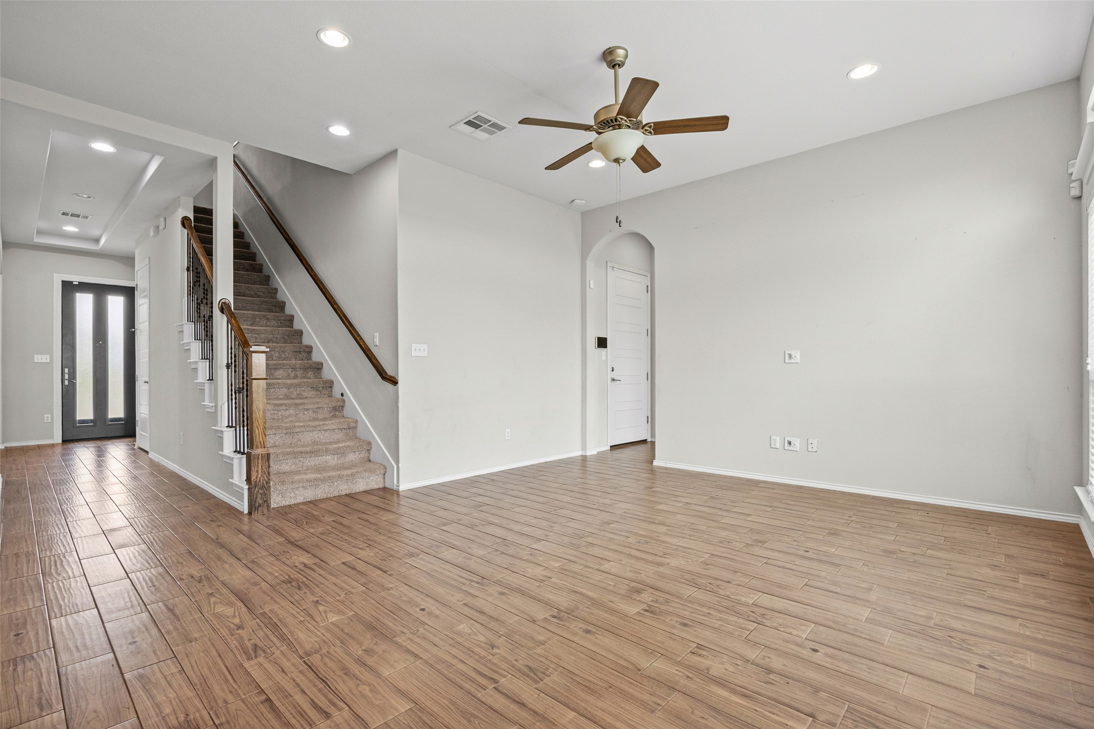 17401 Silent Harbor Loop Pflugerville, TX 78660 - Photo 16 of 37 Unfurnished living room featuring arched walkways, recessed lighting, light wood finished floors, and a ceiling fan