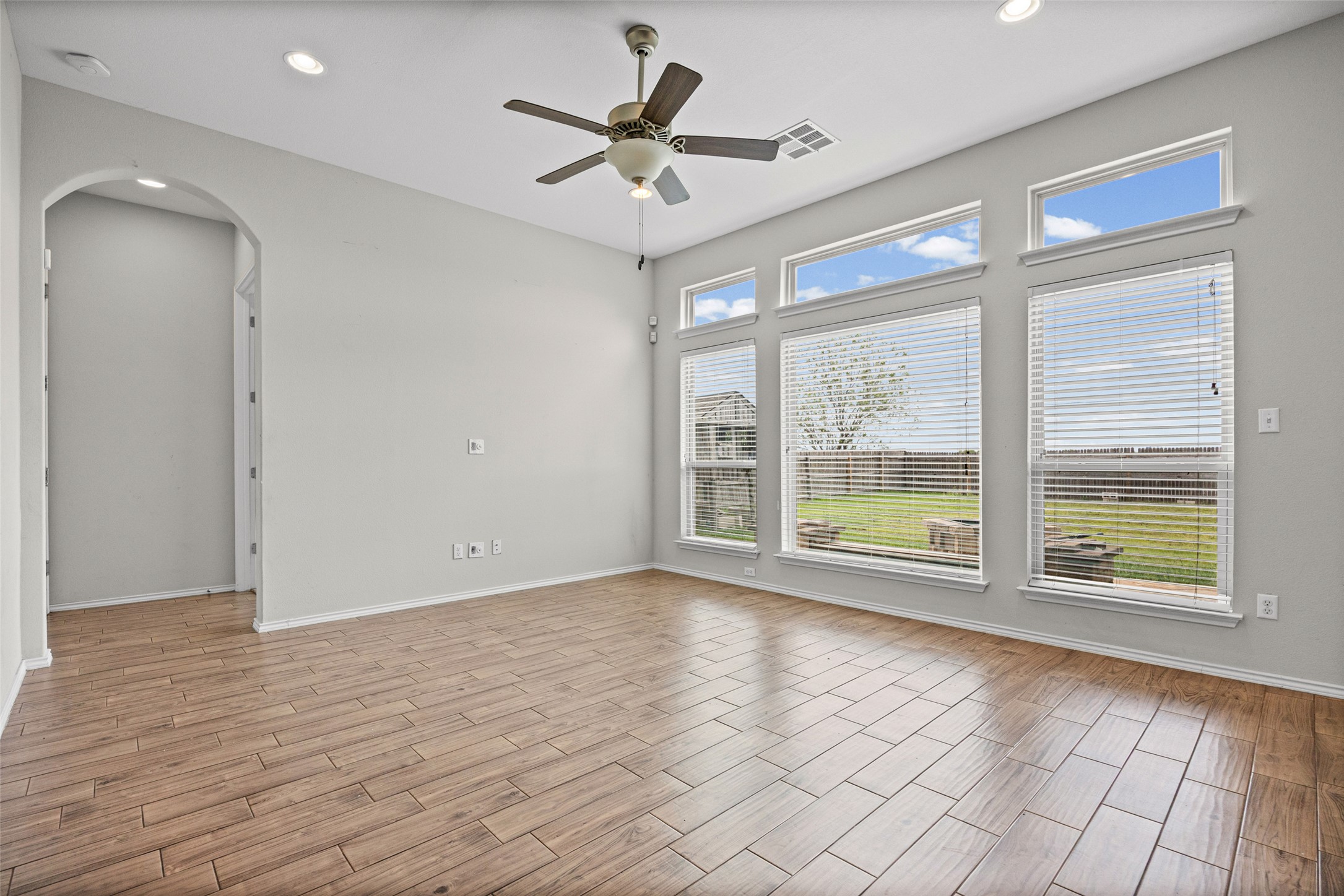 17401 Silent Harbor Loop Pflugerville, TX 78660 - Photo 17 of 37 Unfurnished room featuring arched walkways, wood finish floors, ceiling fan, and recessed lighting