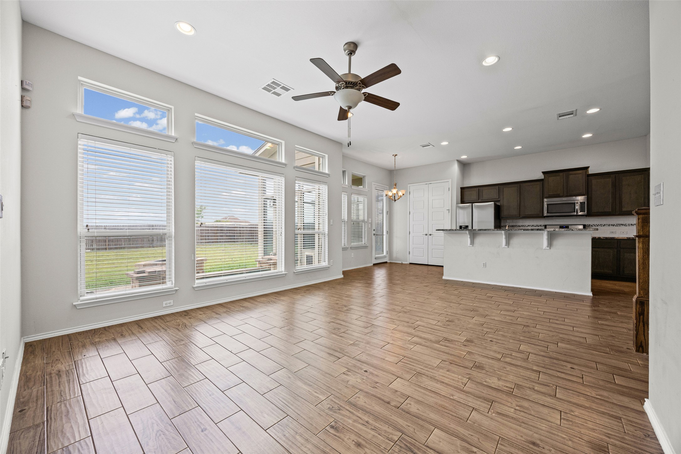 17401 Silent Harbor Loop Pflugerville, TX 78660 - Photo 18 of 37 Unfurnished living room featuring suspended lighting, ceiling fan, and wood finish floors