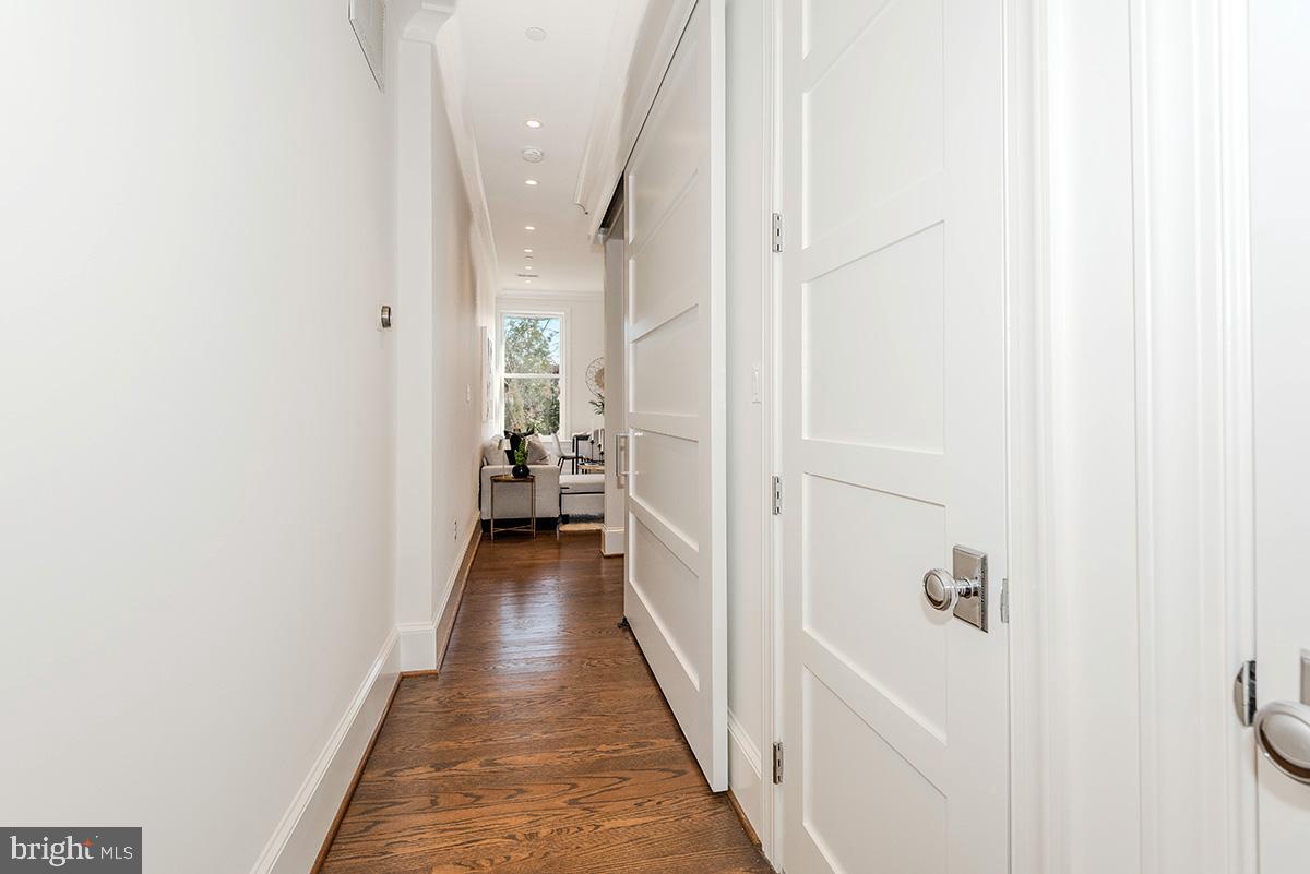 418 7th Street Southeast, Unit 302 Washington, DC 20003 - Photo 7 of 35 a view of a hallway with a white walls and wooden floor