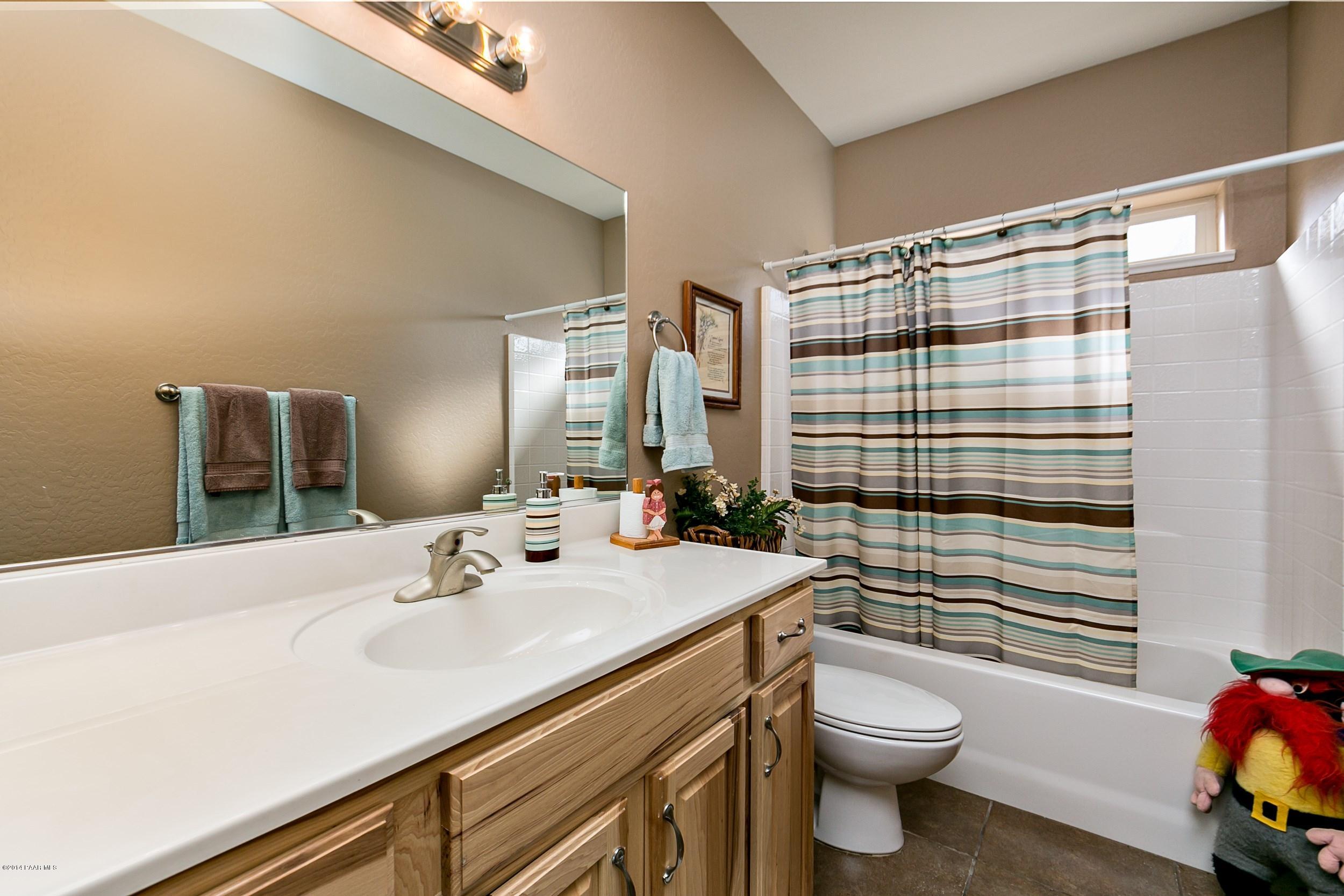 4728 Edgemont Road Prescott Valley, AZ 86314 - Photo 11 of 17 a bathroom with a sink a toilet and shower curtain