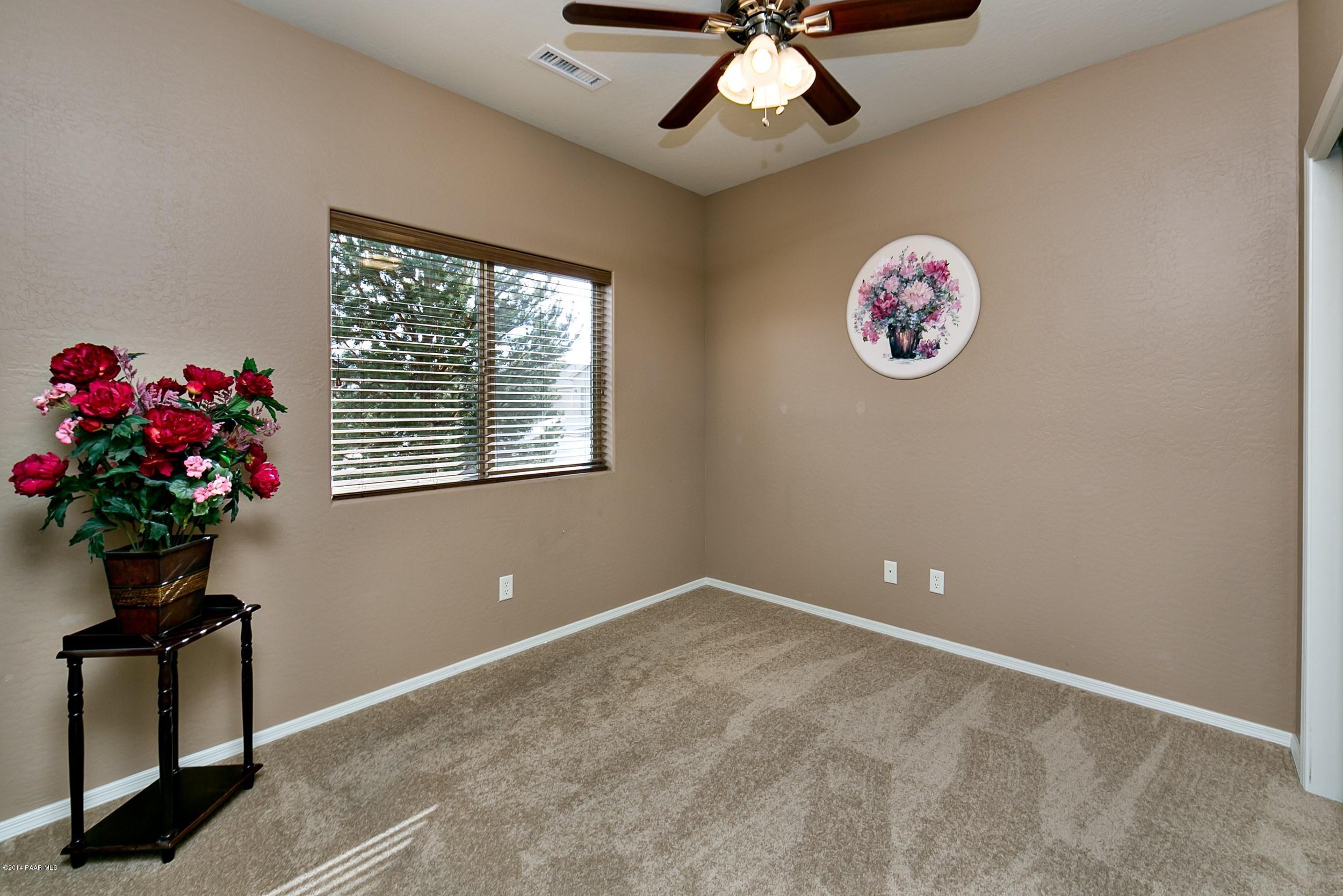 4728 Edgemont Road Prescott Valley, AZ 86314 - Photo 12 of 17 a view of an empty room with a chandelier fan and a window