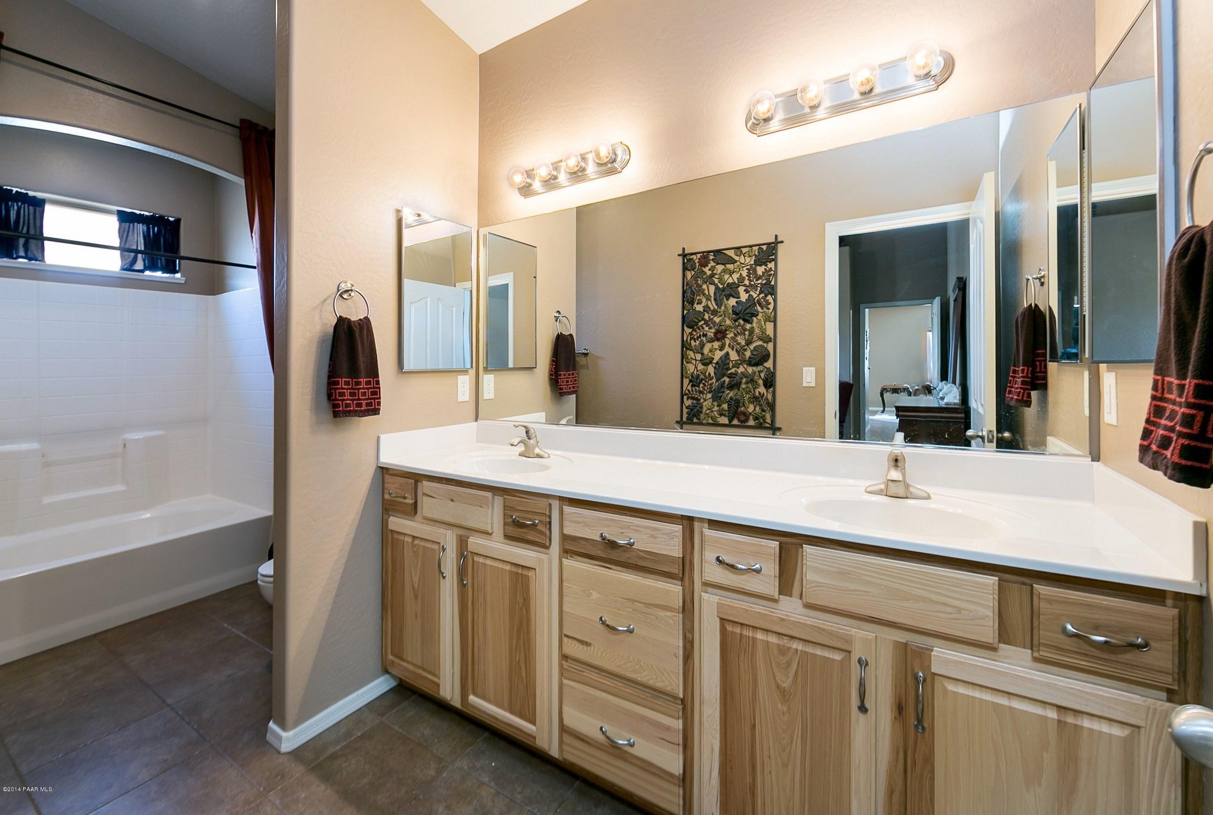 4728 Edgemont Road Prescott Valley, AZ 86314 - Photo 9 of 17 a bathroom with a double vanity sink a mirror and a bathtub