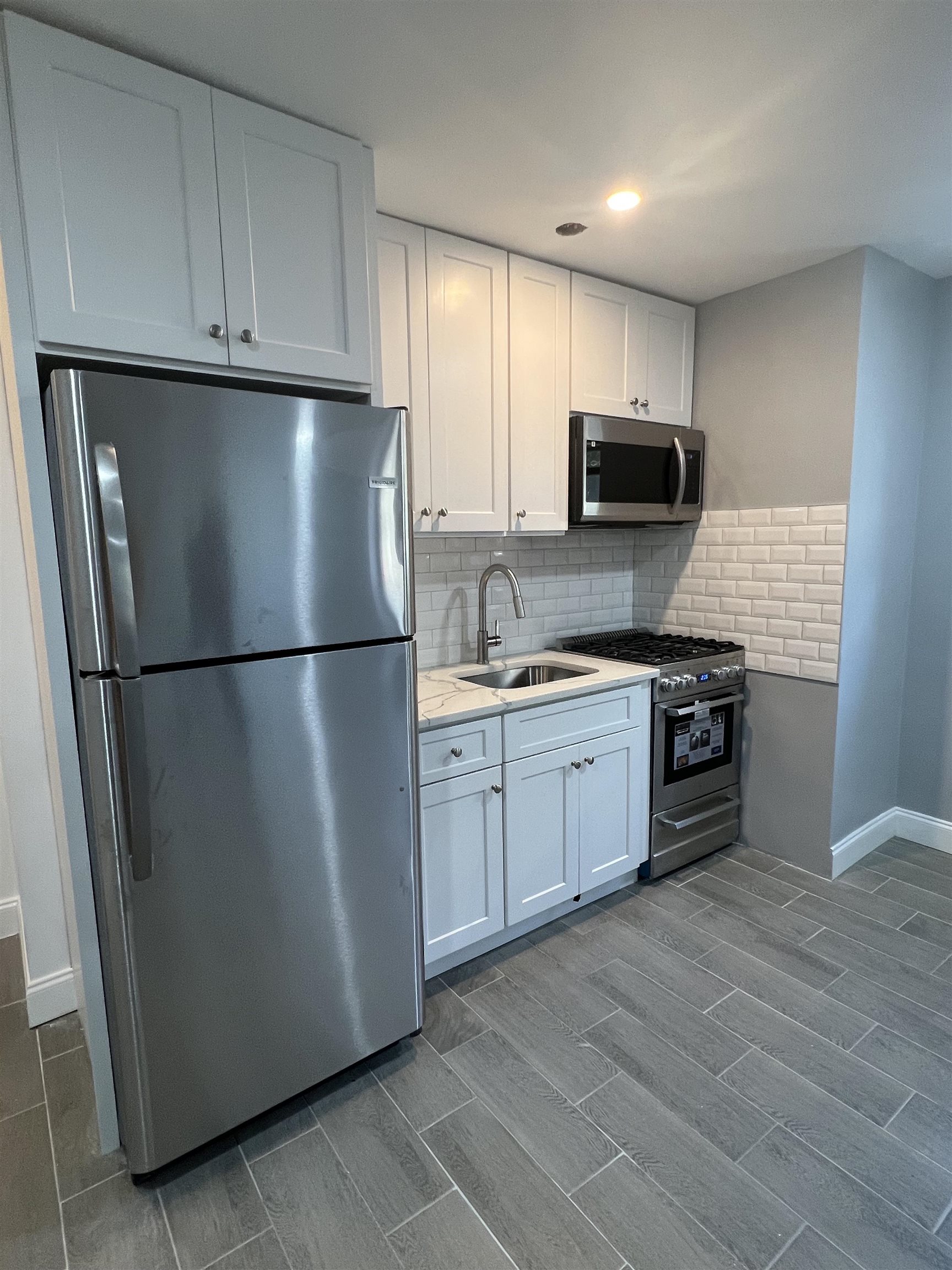 165 Vroom Street, Unit 1F Jersey City, NJ 07306 - Photo 8 of 11 a kitchen with a refrigerator stove and microwave