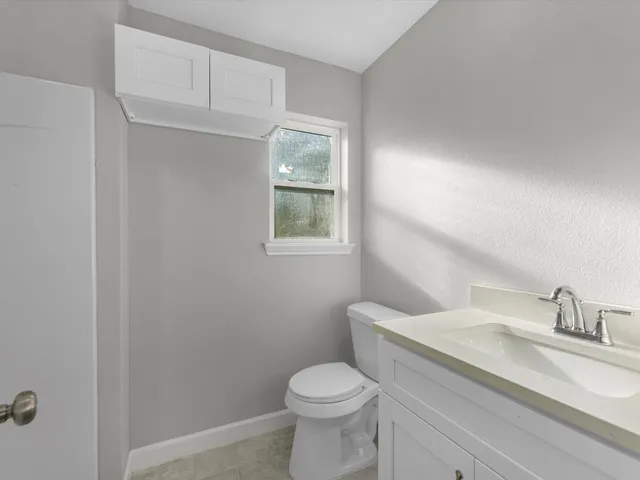 a bathroom with a granite countertop toilet and a sink